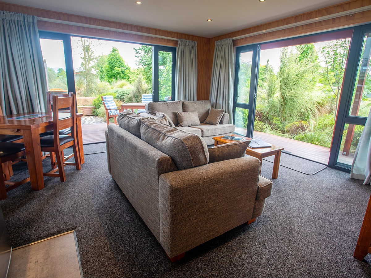 A modern-rustic living area with large glass doors at Musterer's Accommodation, Fairlie.