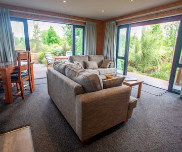 A modern-rustic living area with large glass doors at Musterer's Accommodation, Fairlie.