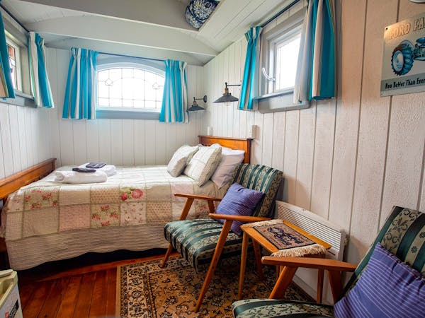 A rustic vintage bedroom with timber walls at Musterer's Accommodation, Fairlie.