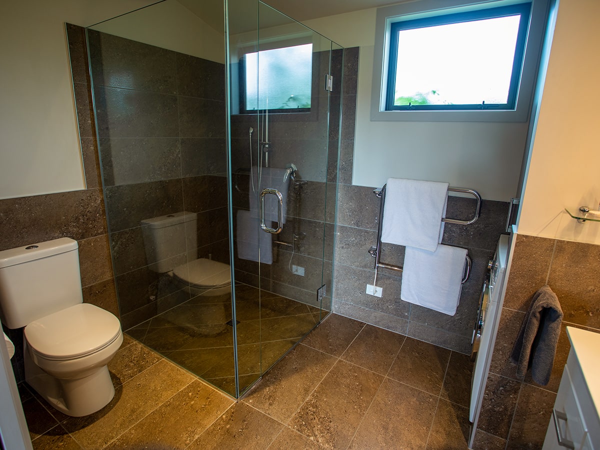 A rustic-modern bathroom with large shower at Musterer's Accommodation, Fairlie.
