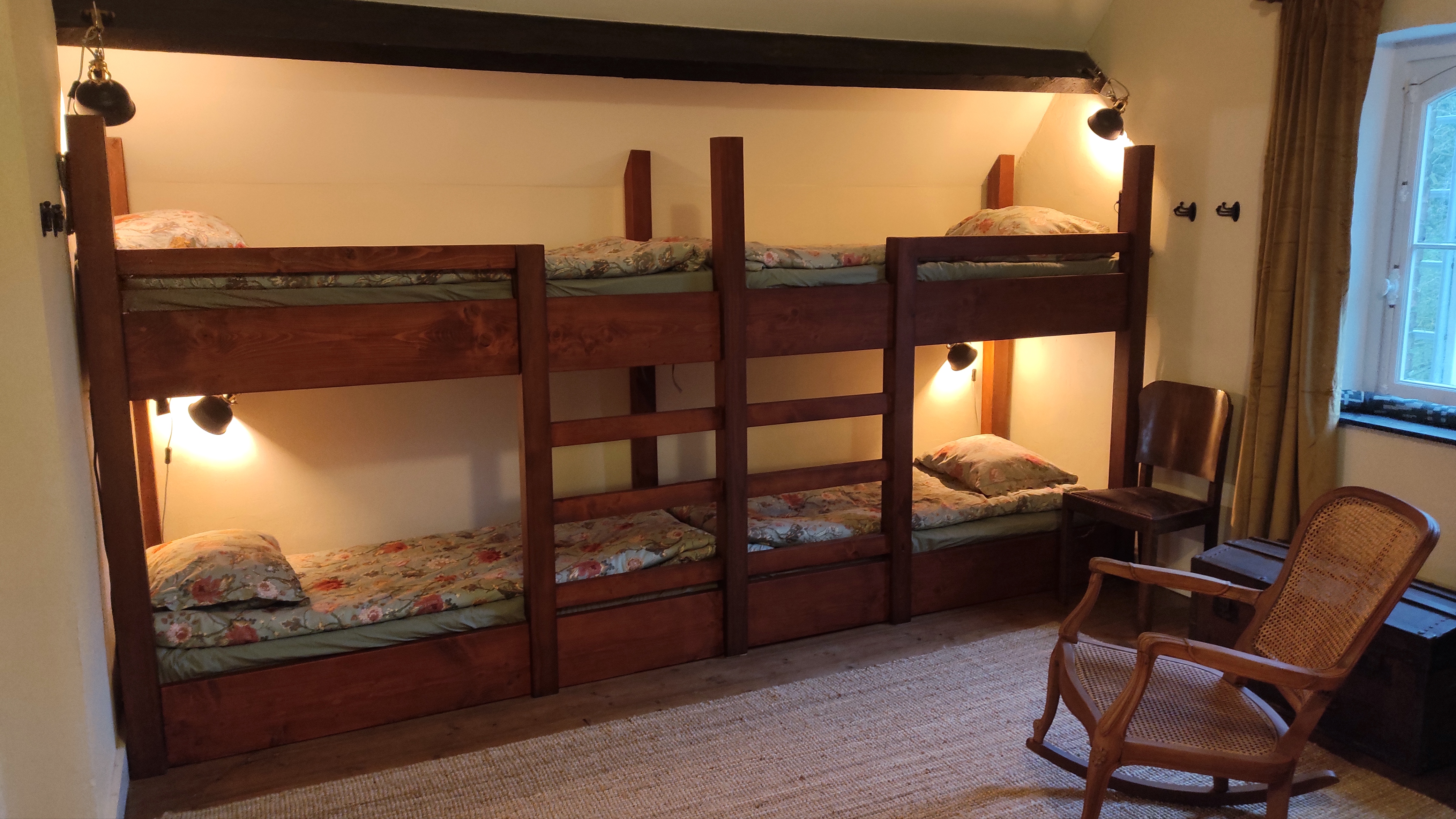 Spacious hostel-style room for eight people at La Maison Vienvenue, featuring individual beds with own lights and sockets