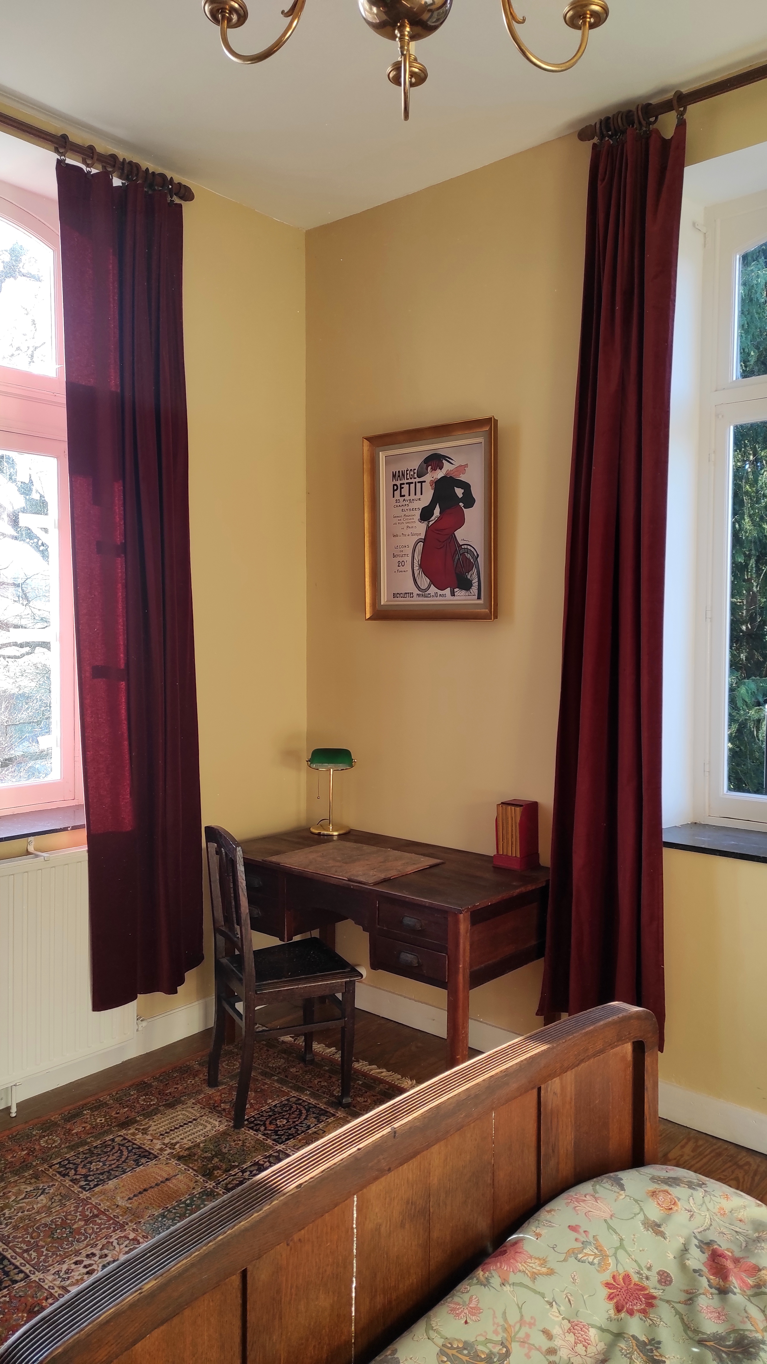 Charming spacious room at La Maison Vienvenue with a desk and authentic cycling-themed decoration.