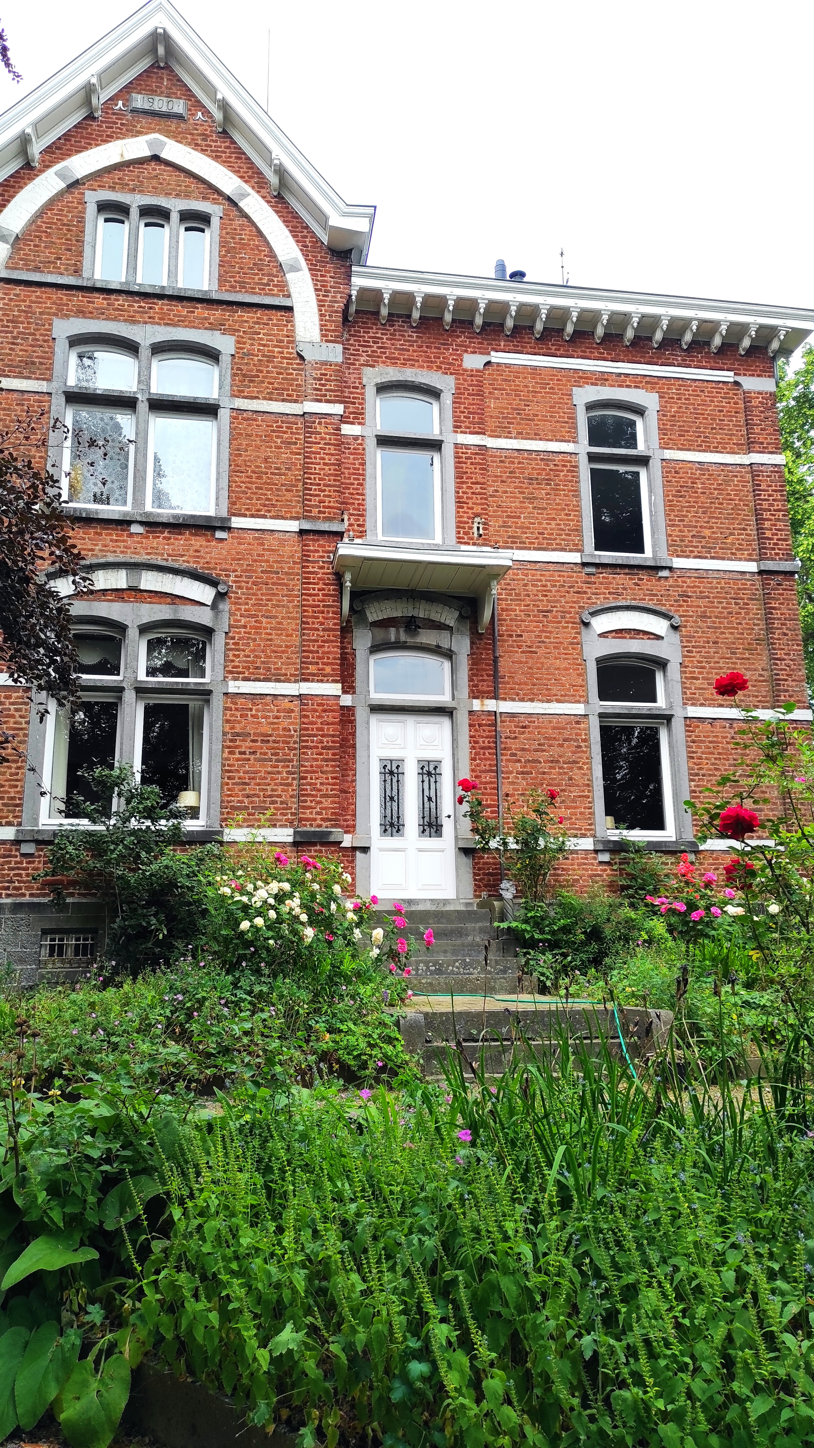 Facade and front garden with flowers of La Maison Vienvenue, a charming accommodation for cyclists in an old manor house.