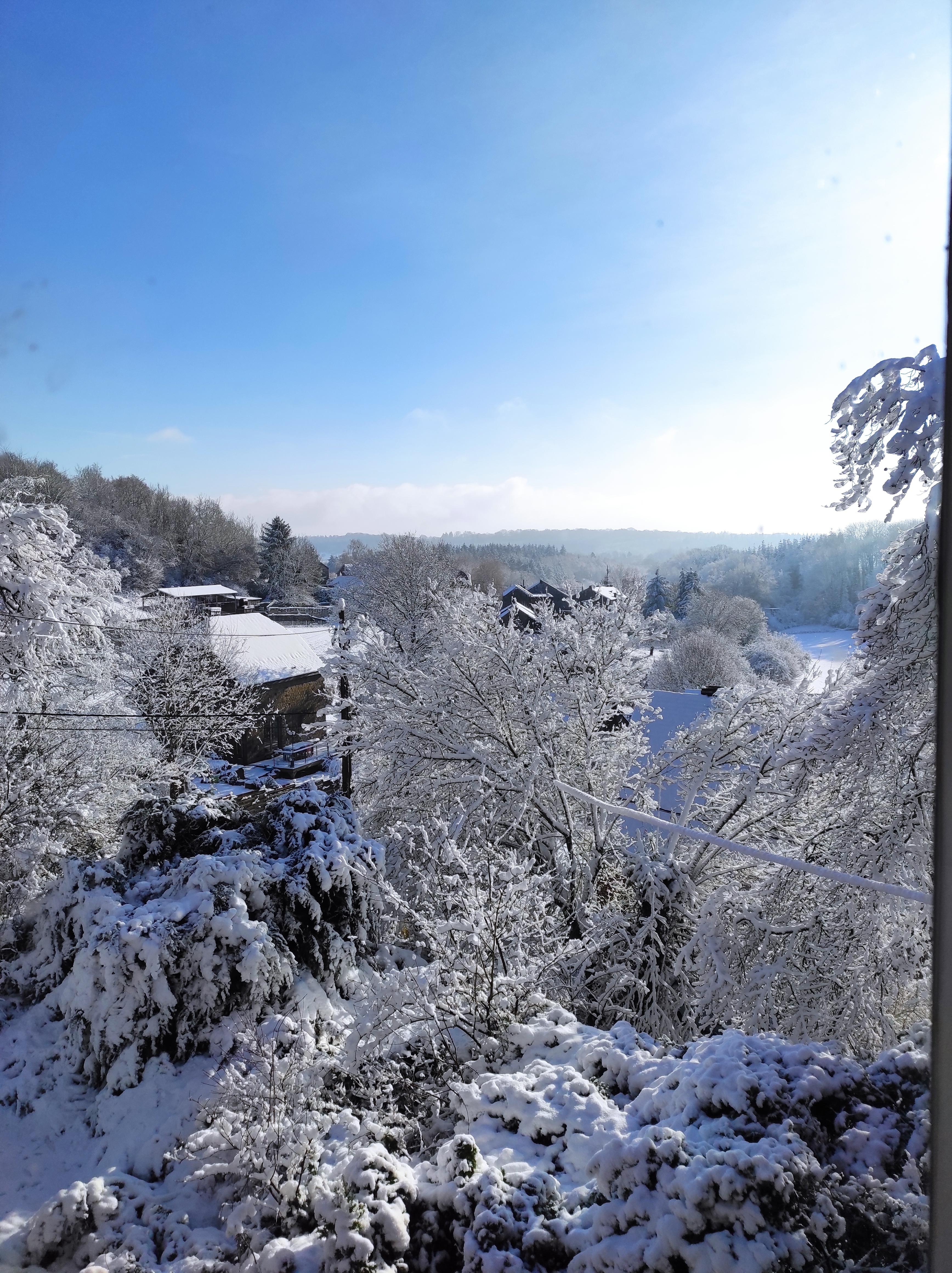 iew of the snowy landscape of the Ourthe Valley from the window of a room at La Maison Vienvenue, a cycling accommodation.