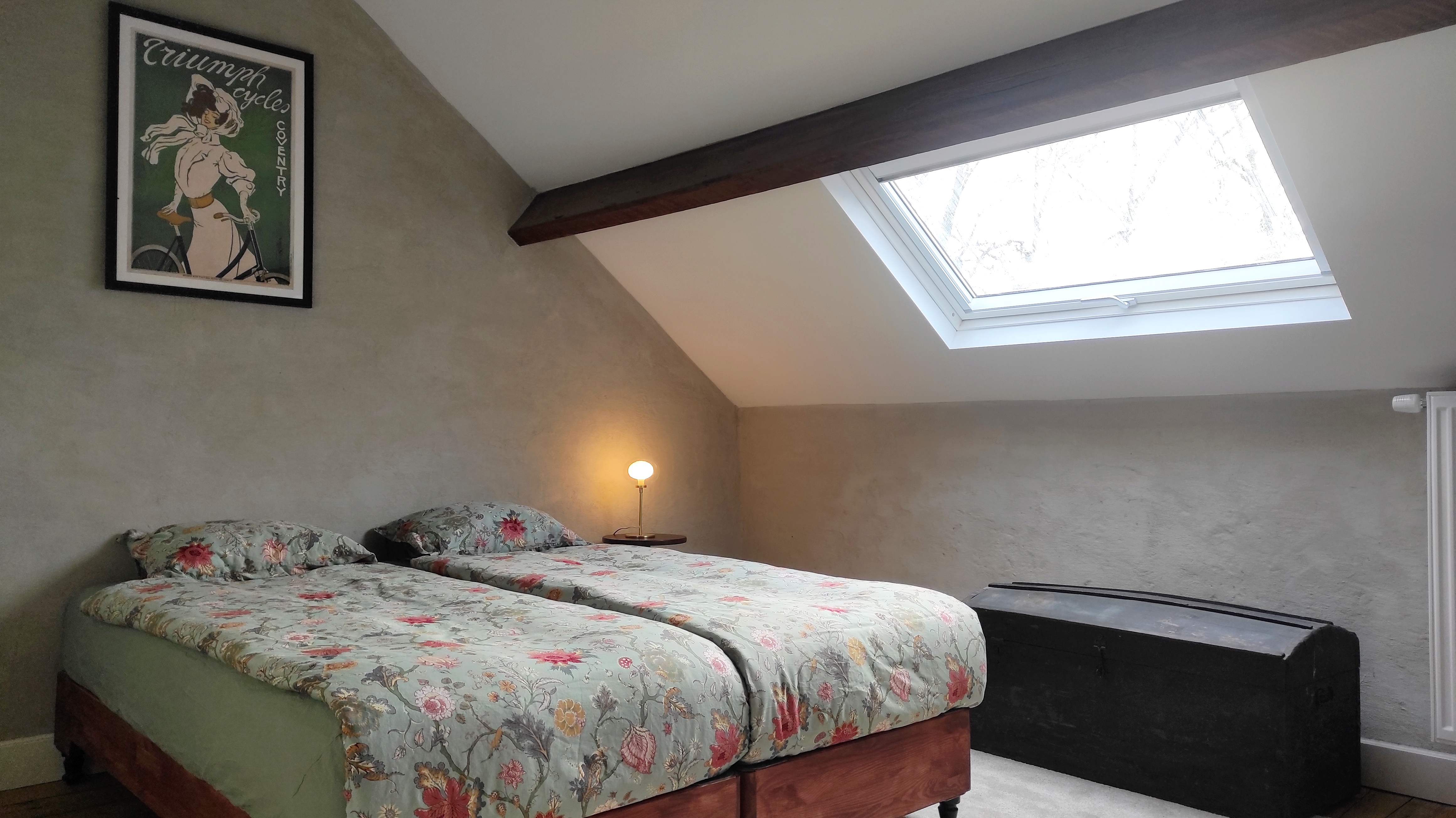 Cozy and charming room at La Maison Vienvenue with its own shower, featuring Art Nouveau style posters and cycling-themed.