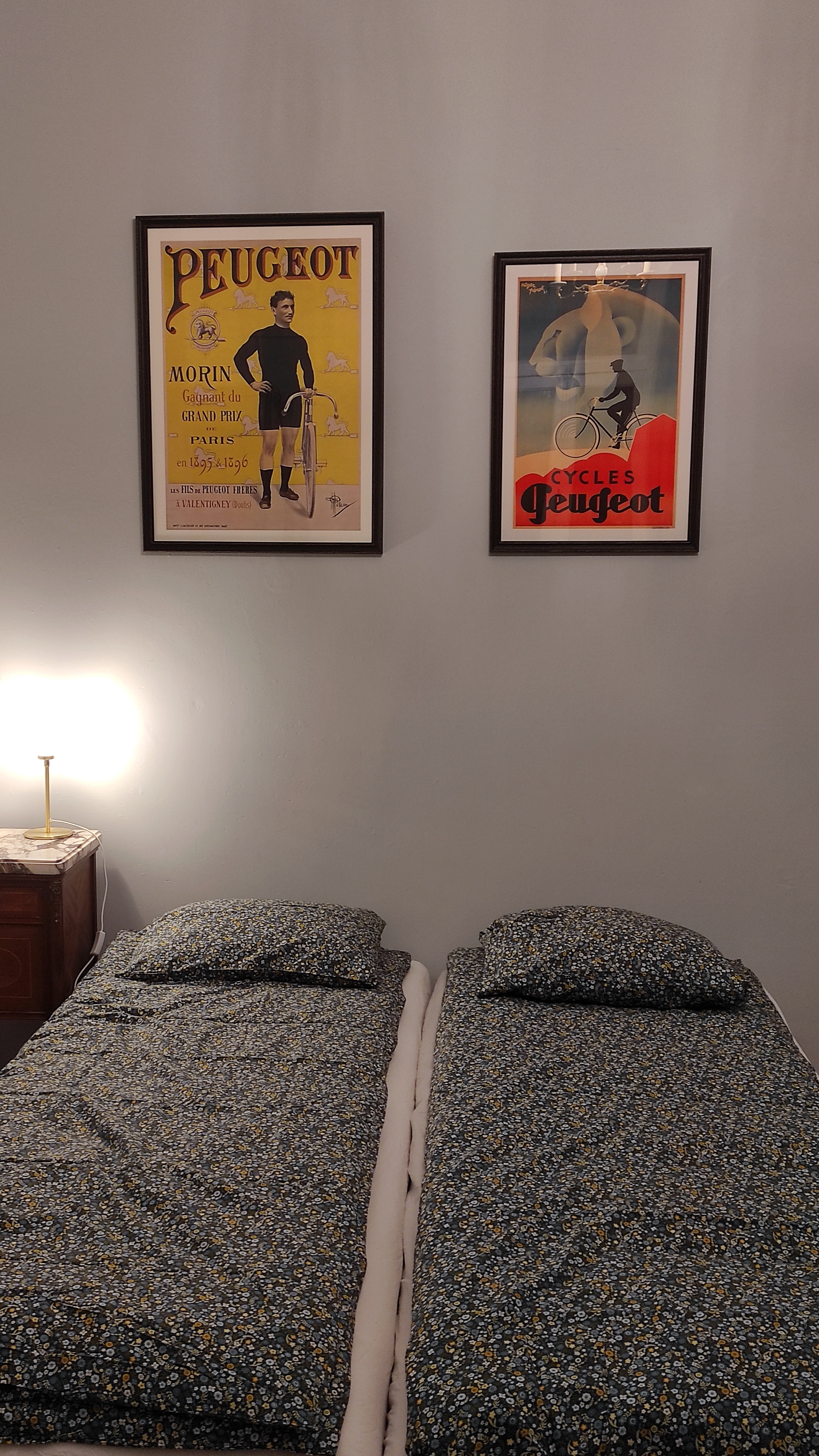 "Charming room for cyclists at La Maison Vienvenue, featuring comfortable beds and retro cycling decoration