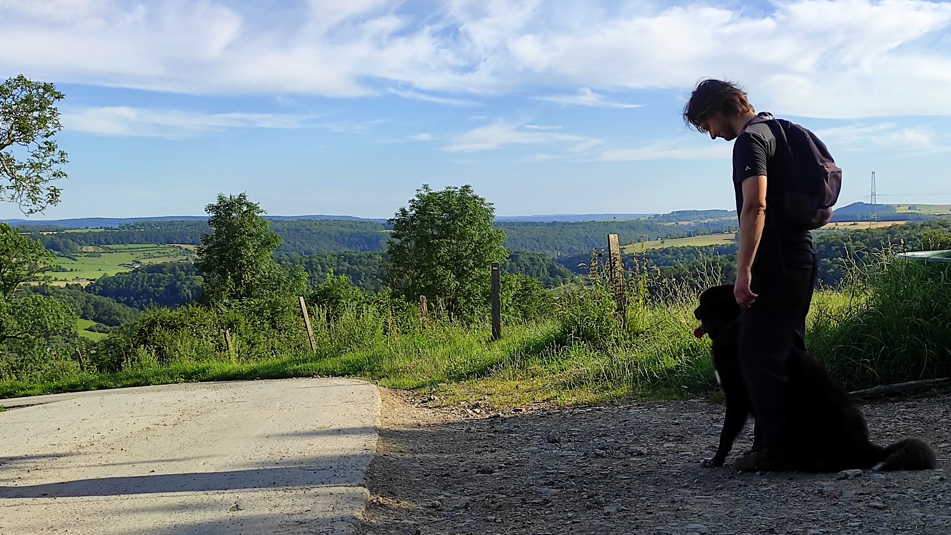 A hiker and his dog enjoying the scenic views over the Ourthe Valley near La Maison Vienvenue.