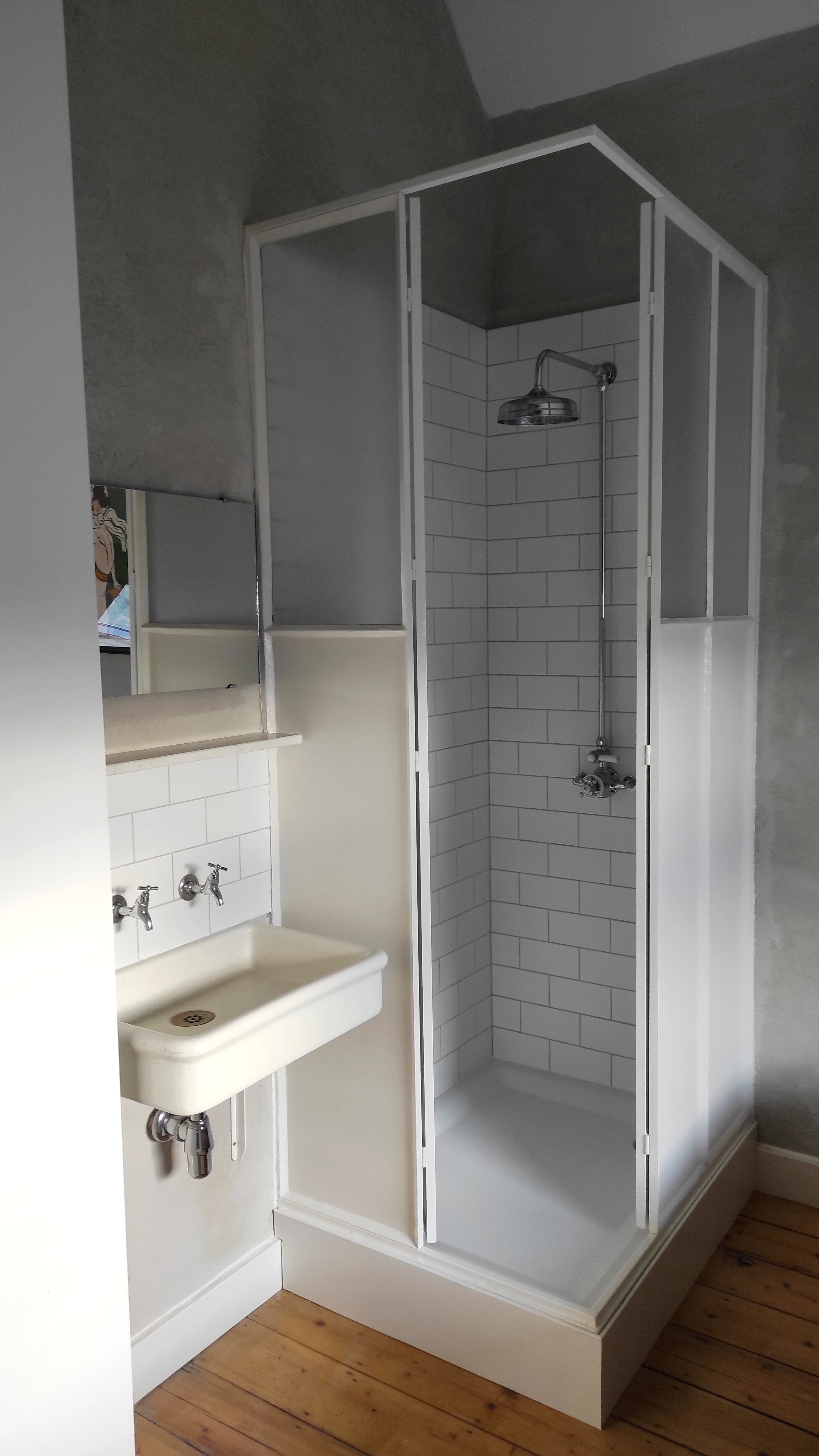 Cozy and charming room at La Maison Vienvenue with its own shower, featuring Art Nouveau style posters and cycling-themed.