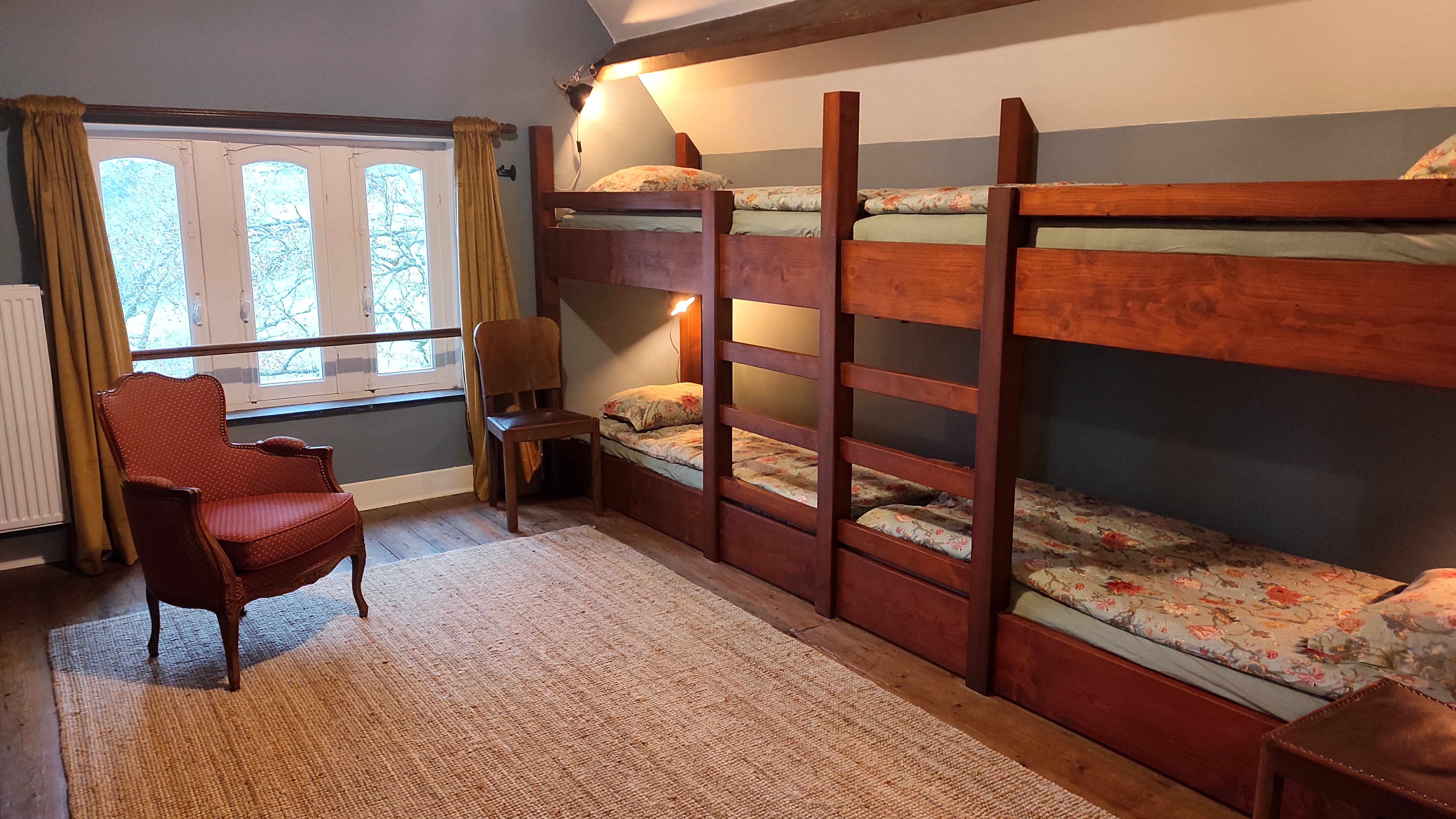 Spacious hostel-style room for eight people at La Maison Vienvenue, featuring individual beds with own lights and sockets