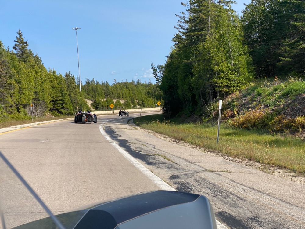Driving a Polaris Slingshot through the scenic winding roads of Manistee National Forest near Best Bear Resort.