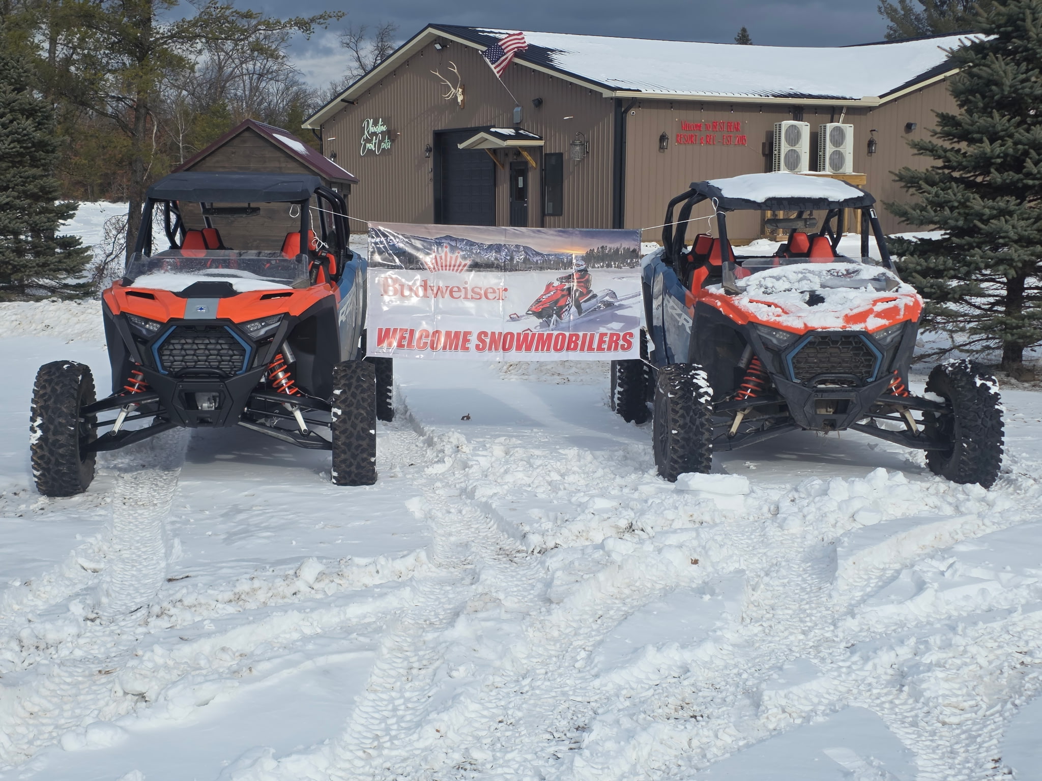 Welcome snowmobilers Budweiser sign tied to two Polaris RZR rentals