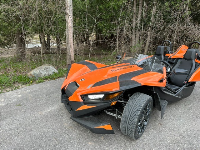 A Polaris Slingshot rental parked at a scenic overlook along the Pine River in Irons MI