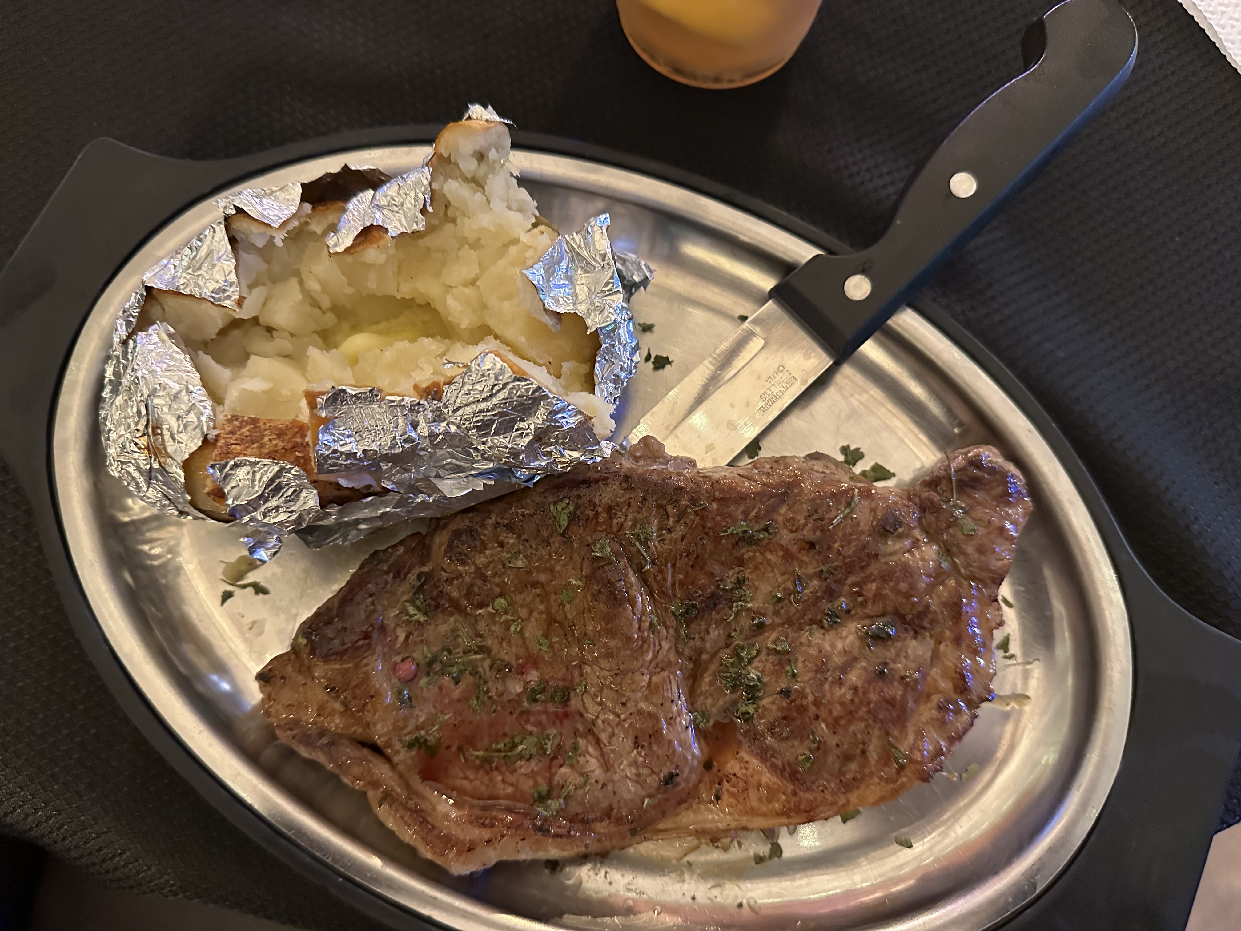Cooked-to-order New York strip steak and a side of traditional baked potato at Best Bear Resort in Irons Michigan