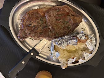 "Cooked-to-order New York strip steak and a side of traditional baked potato."