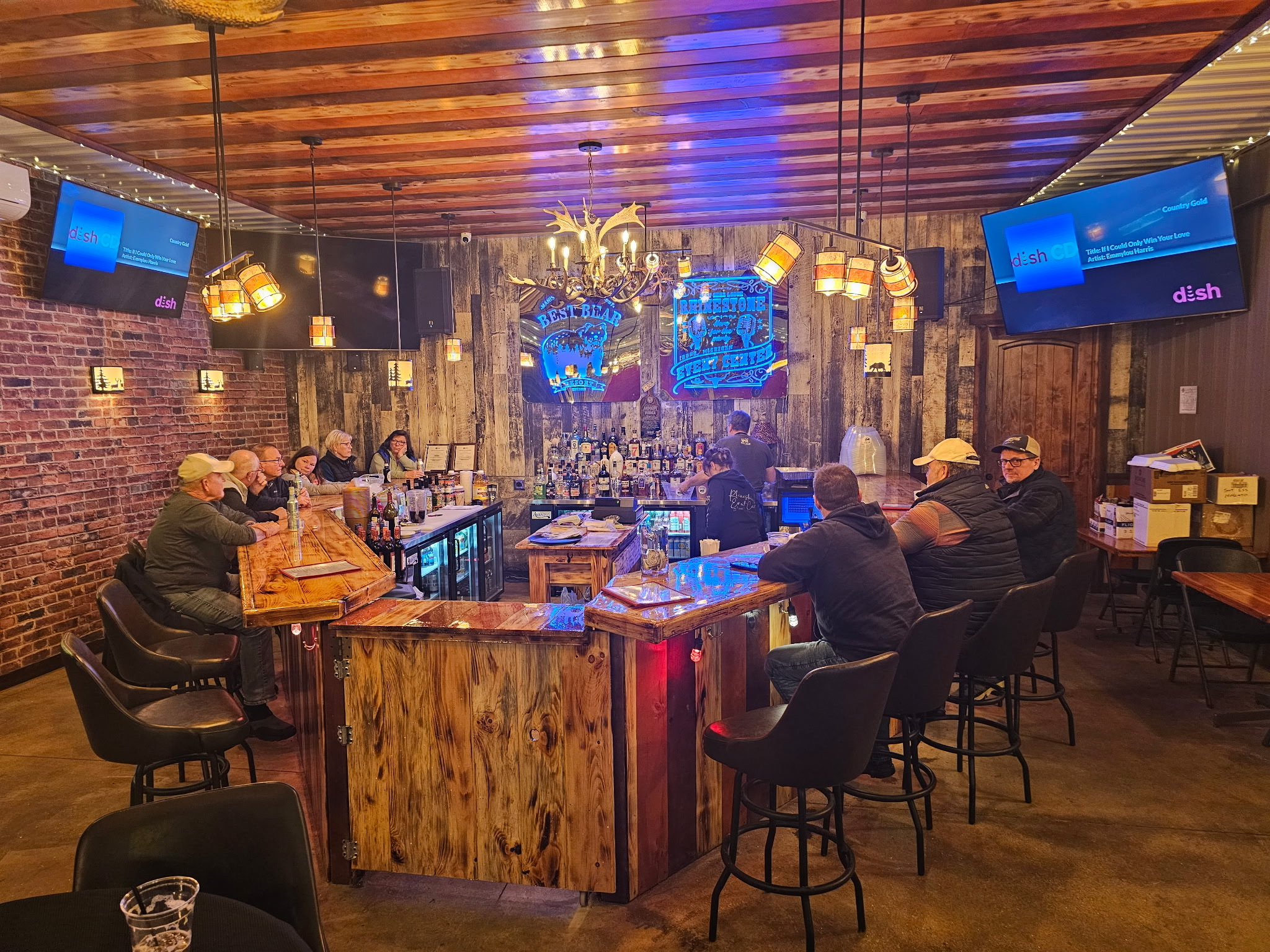 Close-up of a glittering rhinestone bar sign above shelves of alcohol at Best Bear Resort.