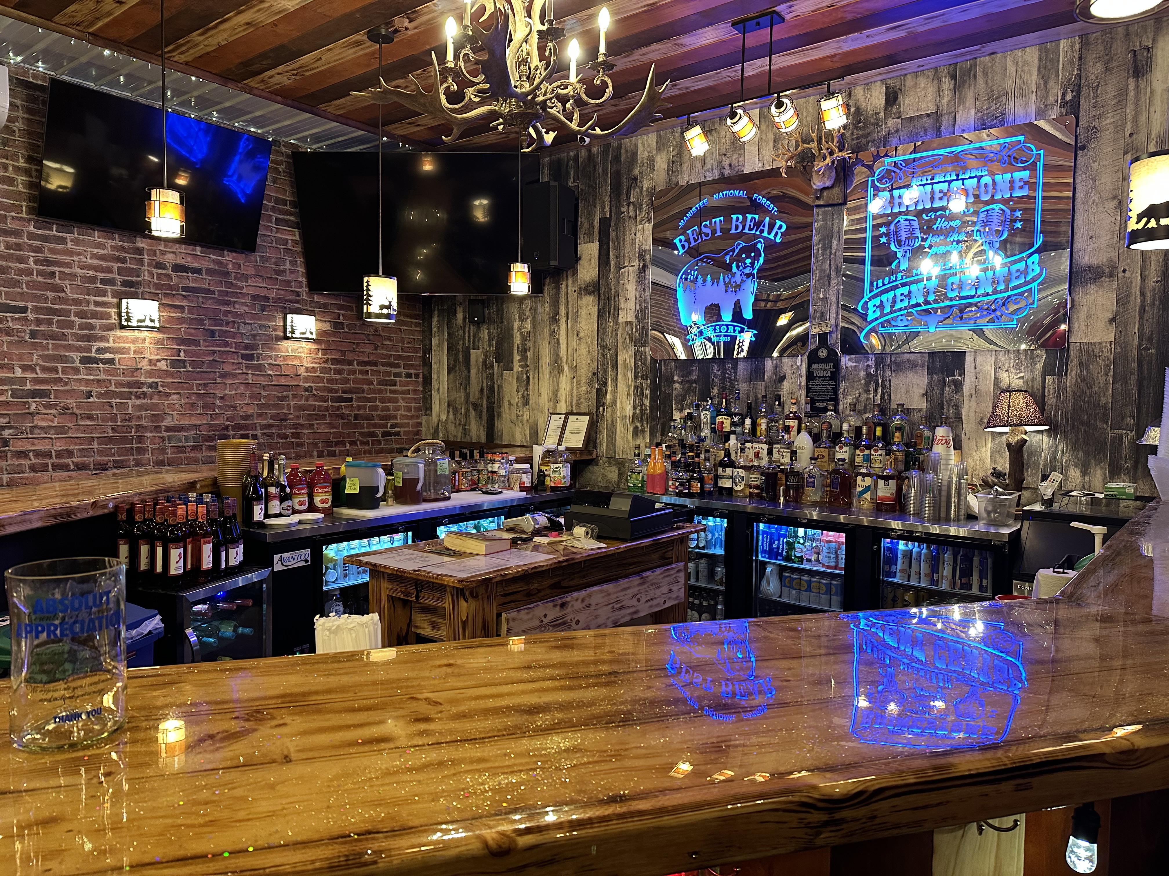 Close-up of a glittering rhinestone bar sign above shelves of alcohol.