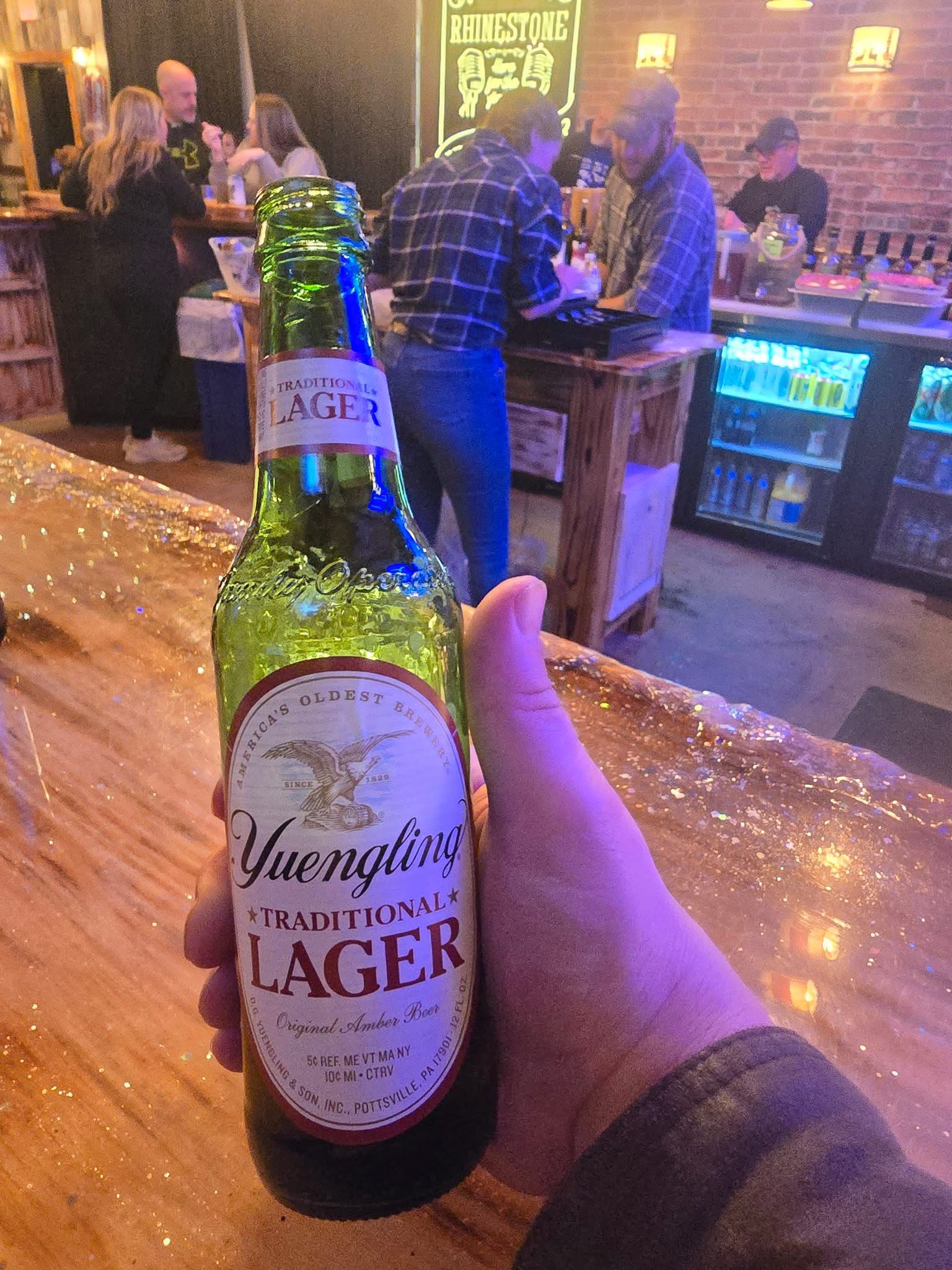 "Close-up of a customer holding a bottle of Yuengling Golden Pilsner."