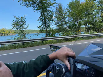 POV driving a Polaris Slingshot past a Michigan lake near Best Bear Resort.