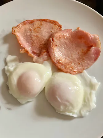 Cooked breakfast. Poached eggs and bacon.