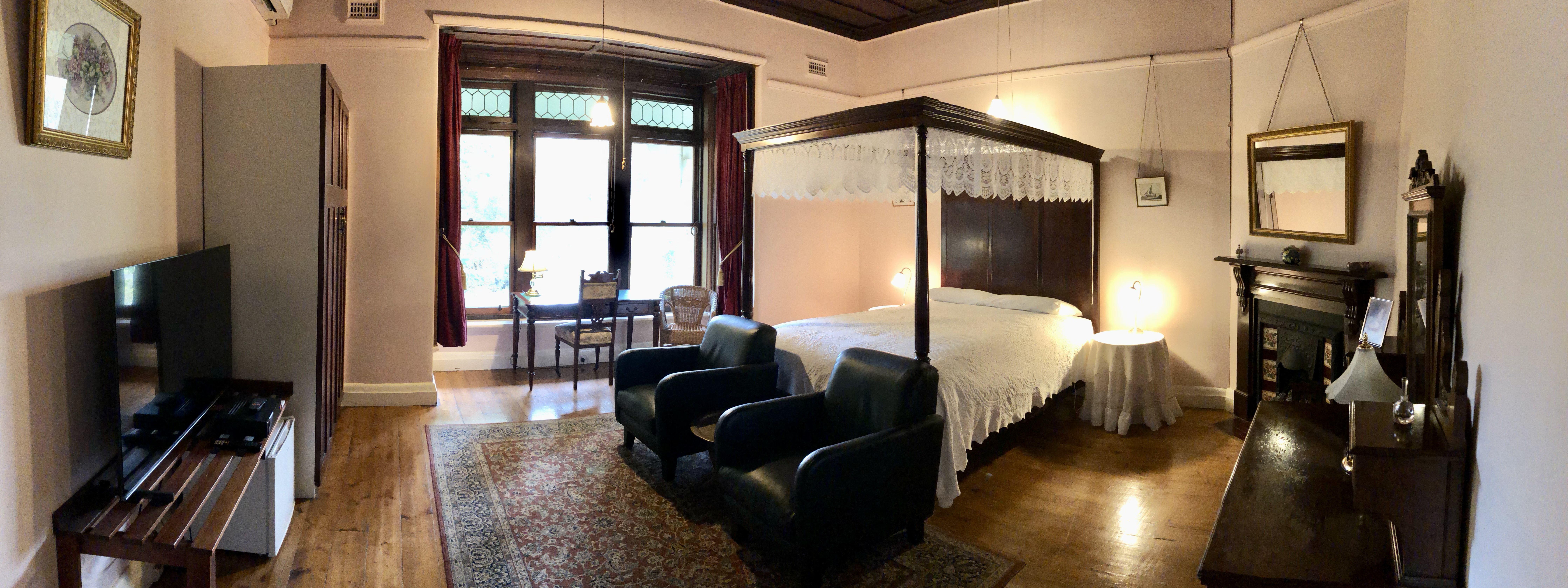 Deluxe Queen room with lounge chairs and smart TV 1