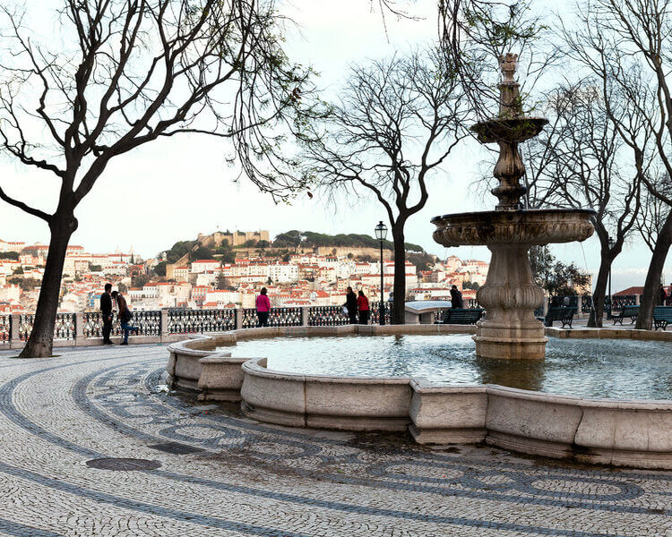 imagem de fonte no miradouro são pedro de alcantara com o castelo de são Jorge ao fundo