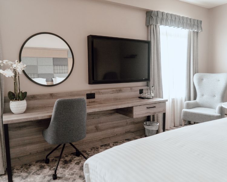 Hotel room setup with a chair and table, providing a comfortable space for guests to unwind or work.