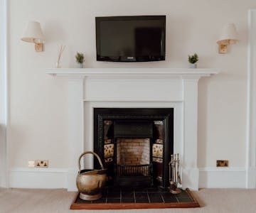 Cosy fireplace with wall mounted TV, creating a warm and inviting ambiance.