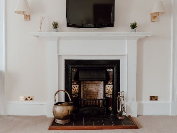 Cosy fireplace with wall mounted TV, creating a warm and inviting ambiance.