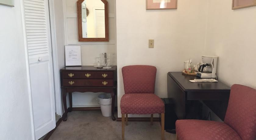 Table, chairs, dresser, and mini-fridge in Prospector Room