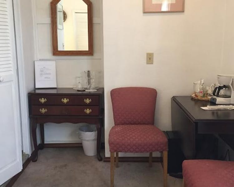 Table, chairs, dresser, and mini-fridge in Prospector Room