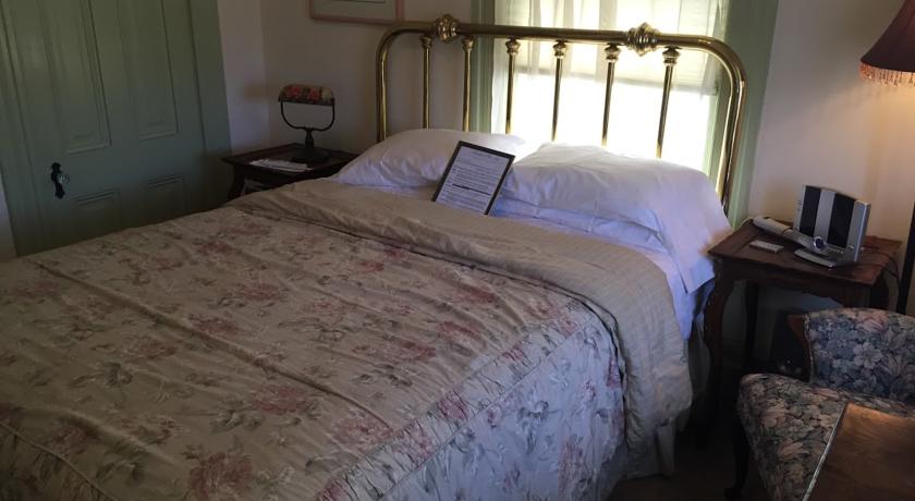 Queen bed with brass headboard in Tioga Room