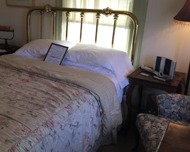 Queen bed with brass headboard in Tioga Room