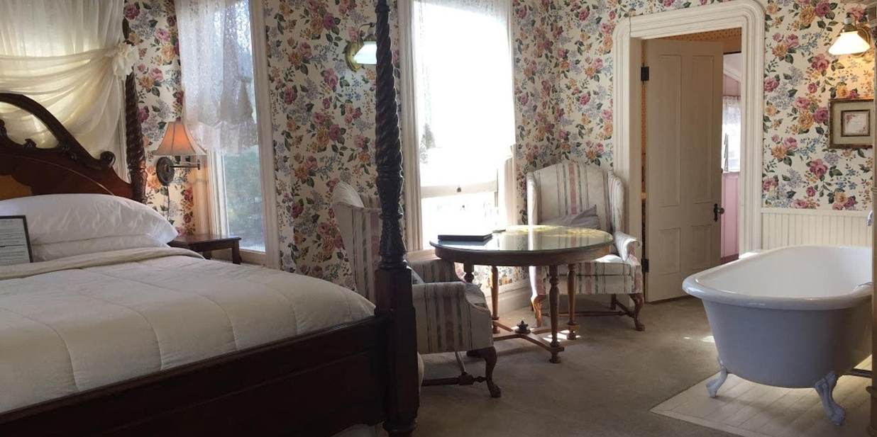 Four post king bed and table in Bradford Suite