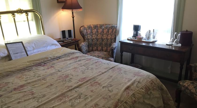 Bed, nightstand, window, and table in Tioga Room