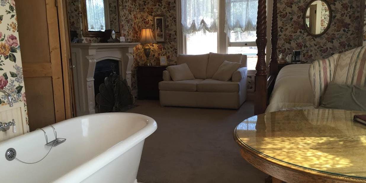 Claw foot tub, fireplace, and sofa sleeper in the Bradford Suite