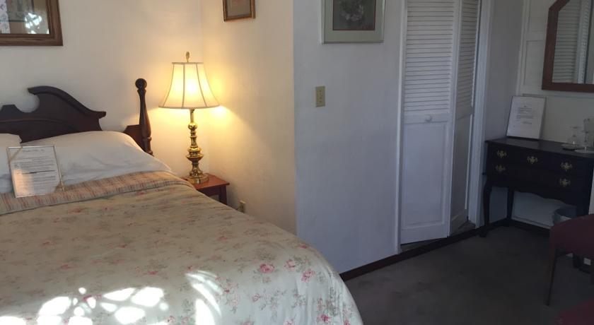 Queen bed and entrance to private bath in Prospector Room