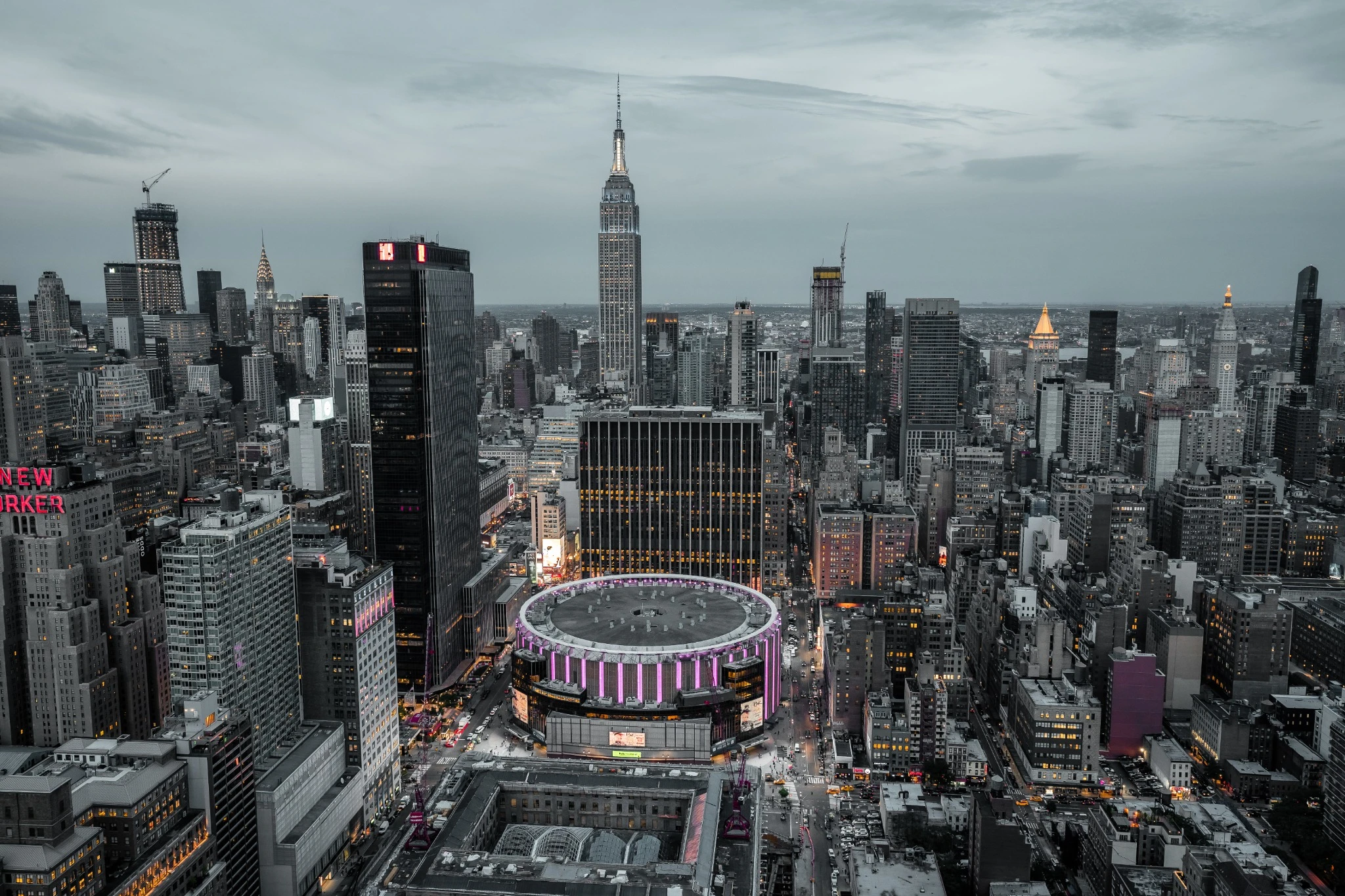 Madison square garden lit up purple on a cloudy evening.