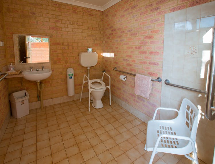 "Disabled bathroom with hand railing and shower chair"