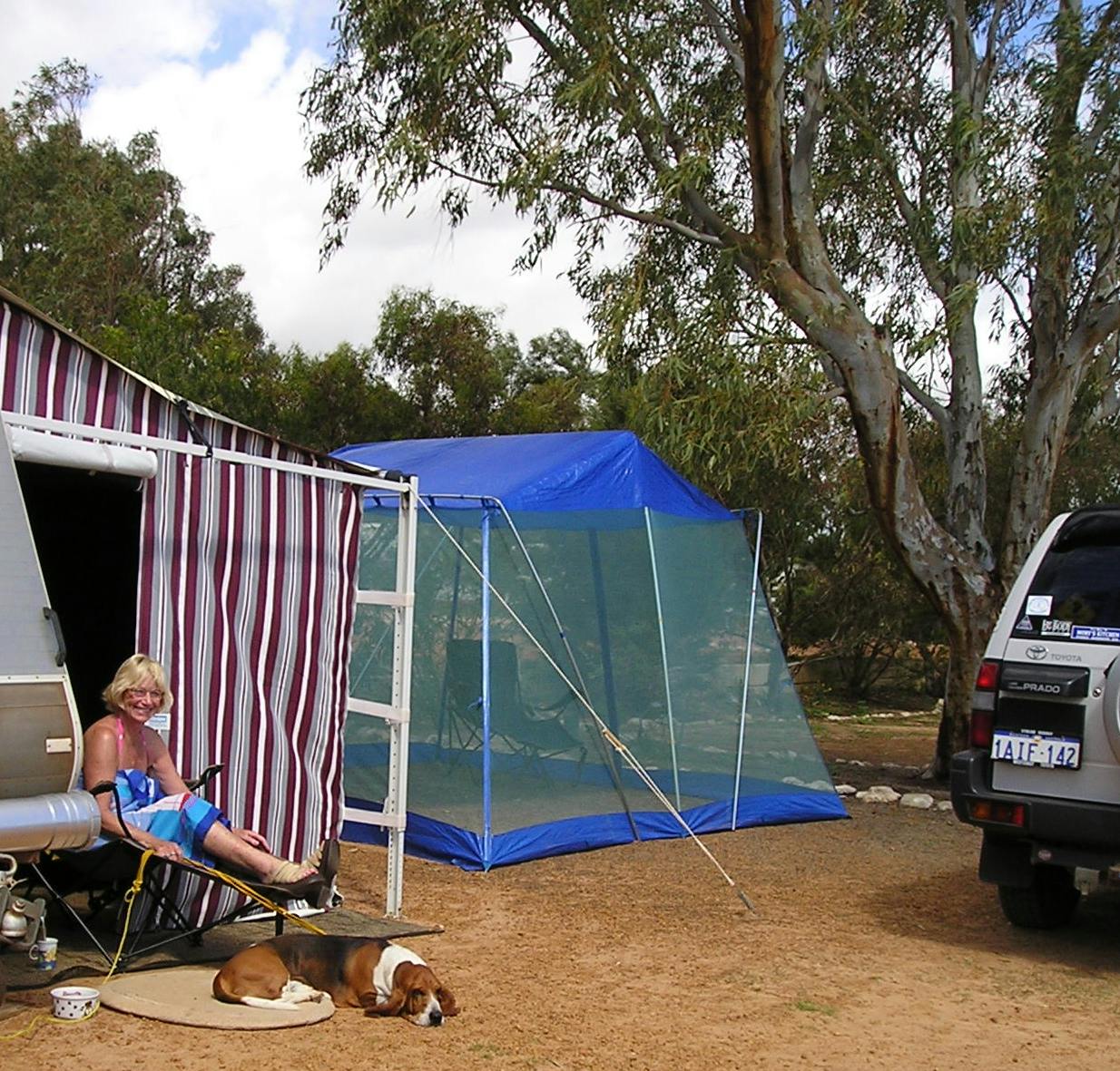 "Lady sitting with dog outside of a Caravan anex in a powered site"