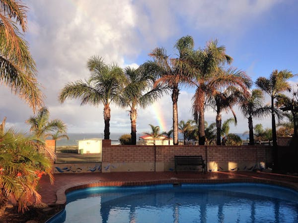 "Drummond Cove Holiday Park pool area with rainbow in the background"