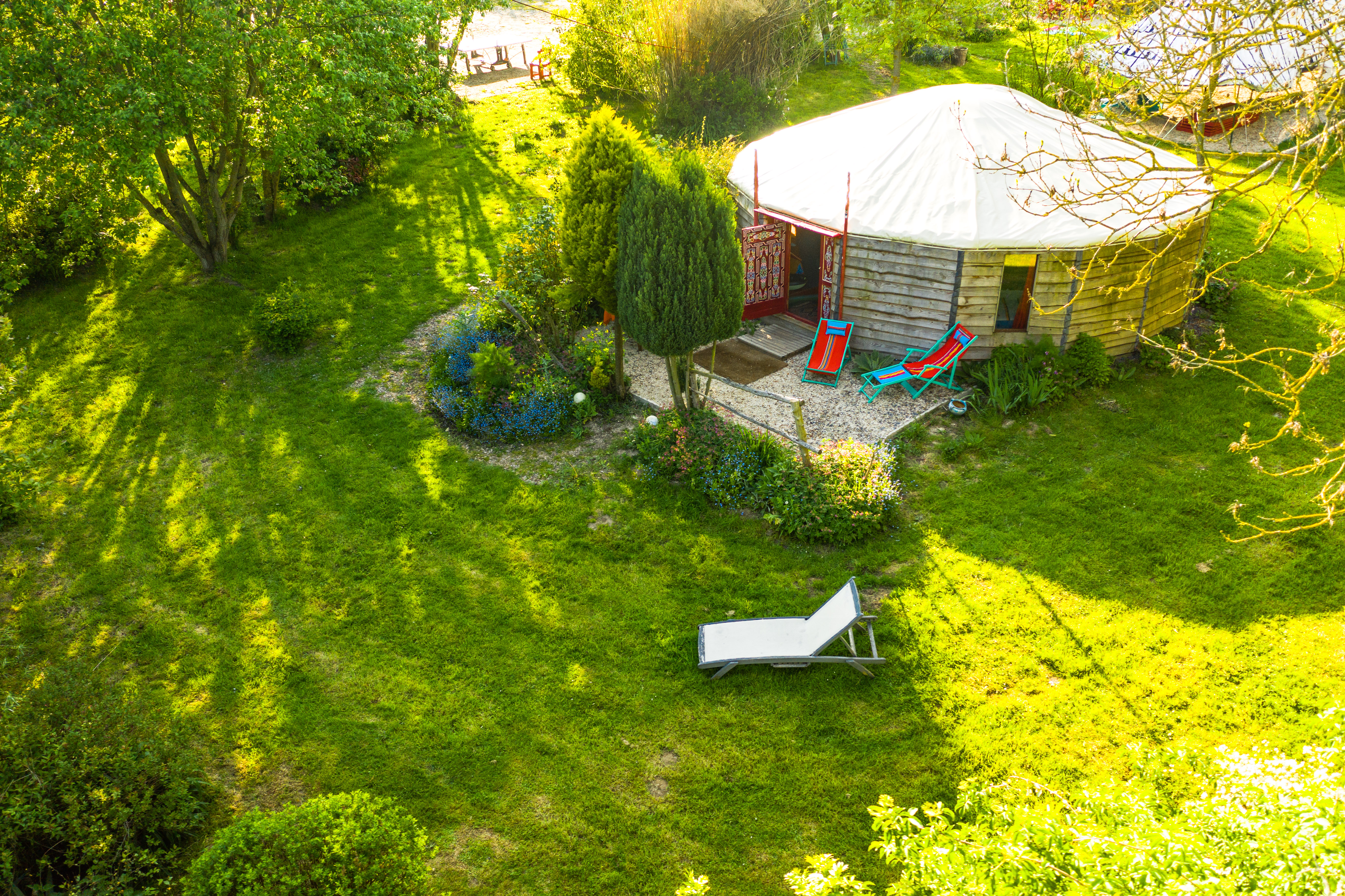Vue aérienne de la yourte contemporaine rouge de 48m² avec sa terrasse et son jardin.