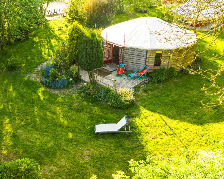 Vue aérienne de la yourte contemporaine rouge de 48m² avec sa terrasse et son jardin.