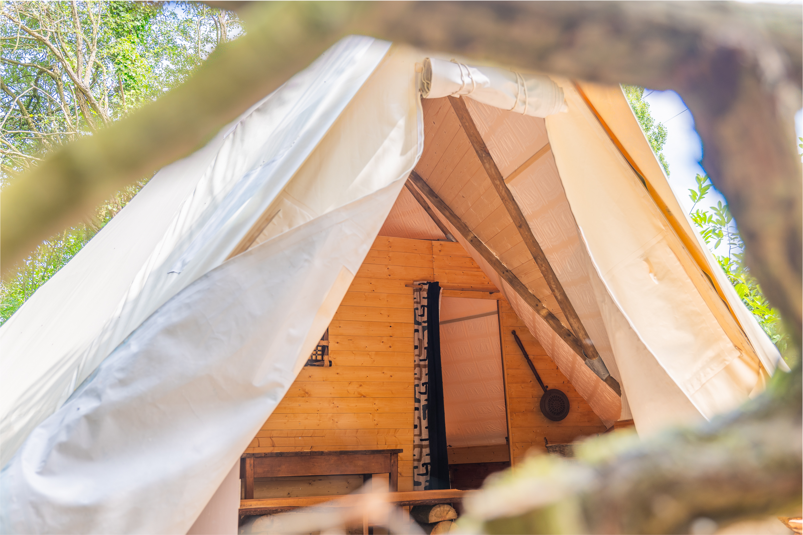 Au-Bonheur-Nomade - vue intérieure du tipi trappeur par le bois de la terrasse fait maison
