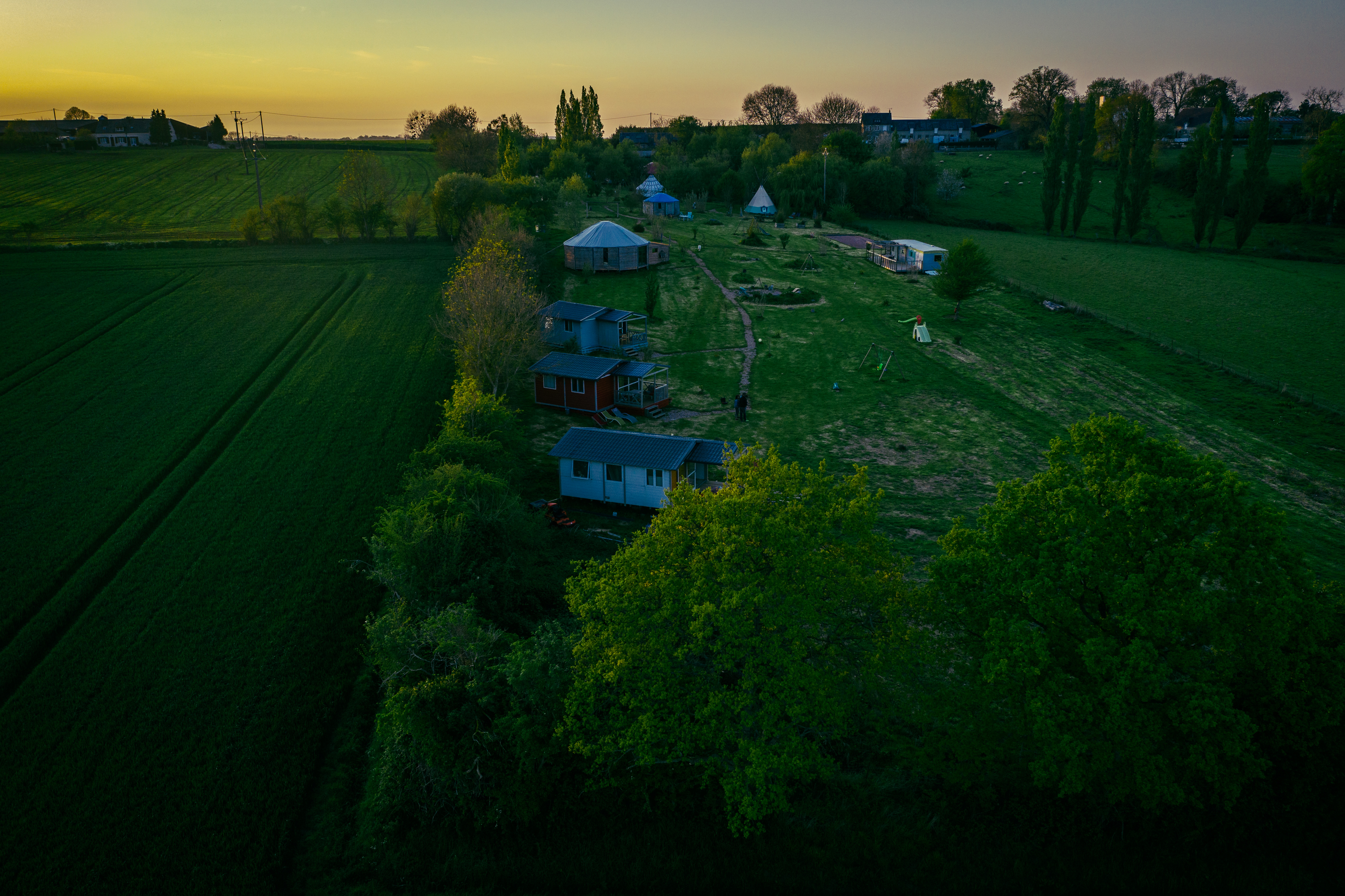 Vue aérienne sur une partie du domaine. Chalets en cours de constructions, yourtes, tipis, tente caïdale et le mobil home.