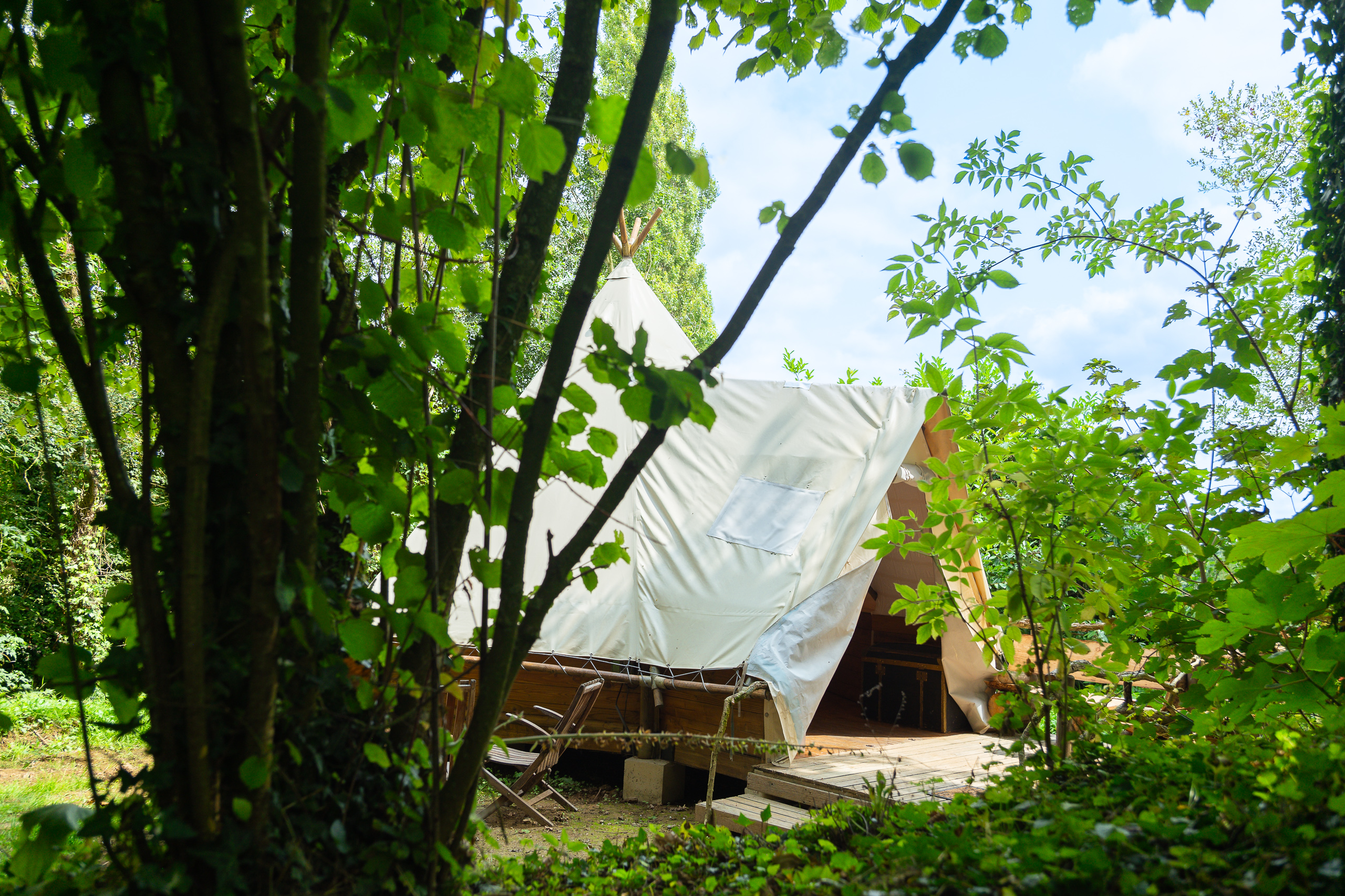 Au-Bonheur-Nomade - vue extérieure du tipi trappeur, à travers les arbres