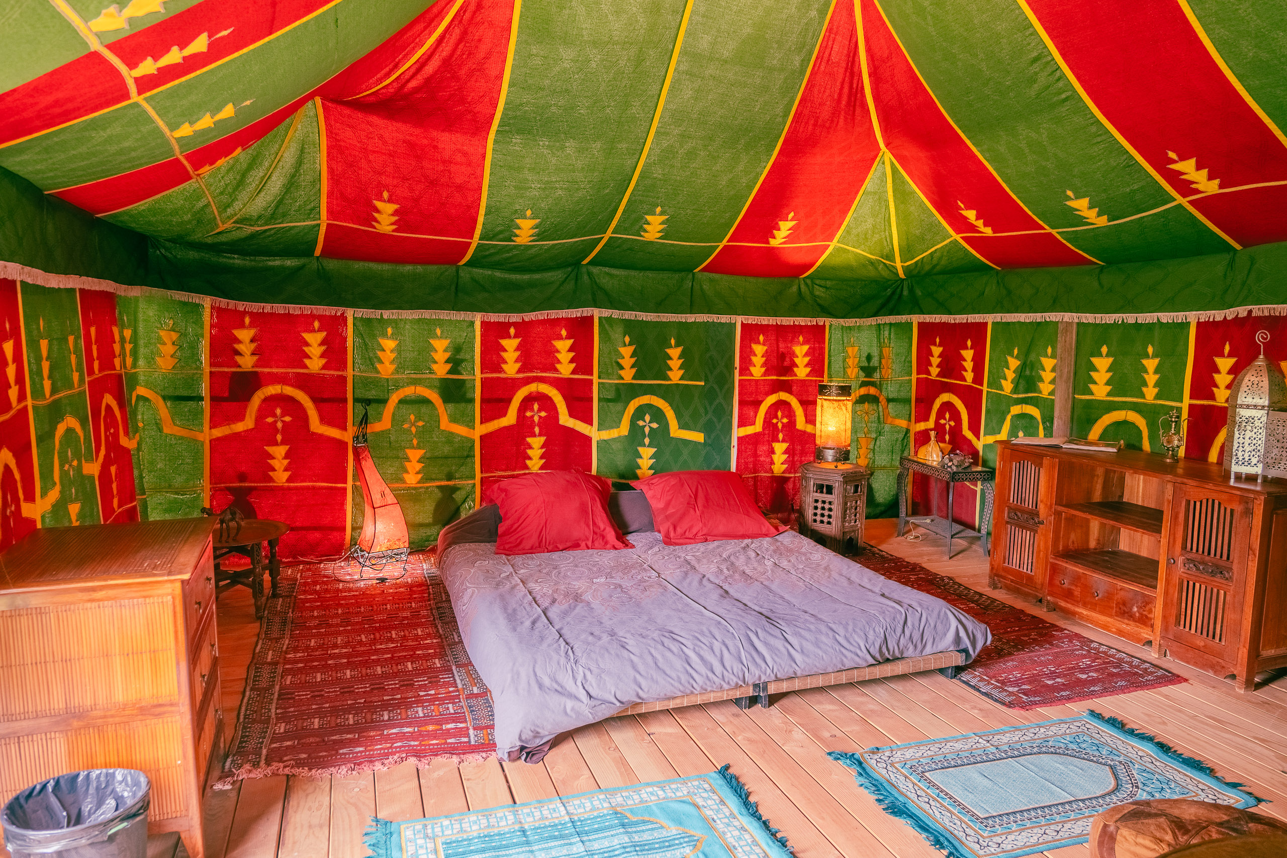 Au-Bonheur-Nomade - vue intérieure de la tente caïdale Marocaine. Plan sur le lit double, kingsize et les table de chevet