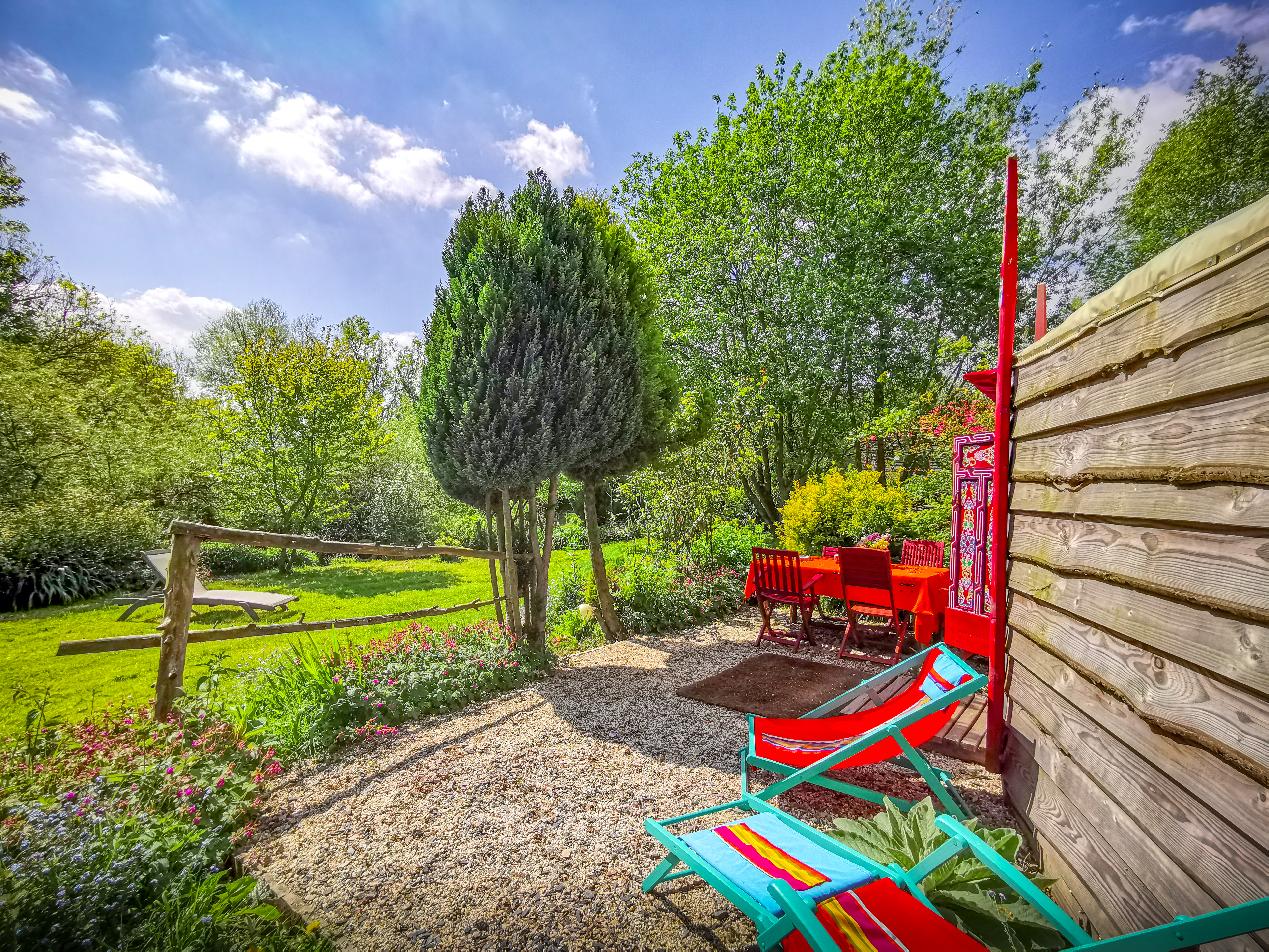Extérieur de la yourte rouge, vue sur son jardin.