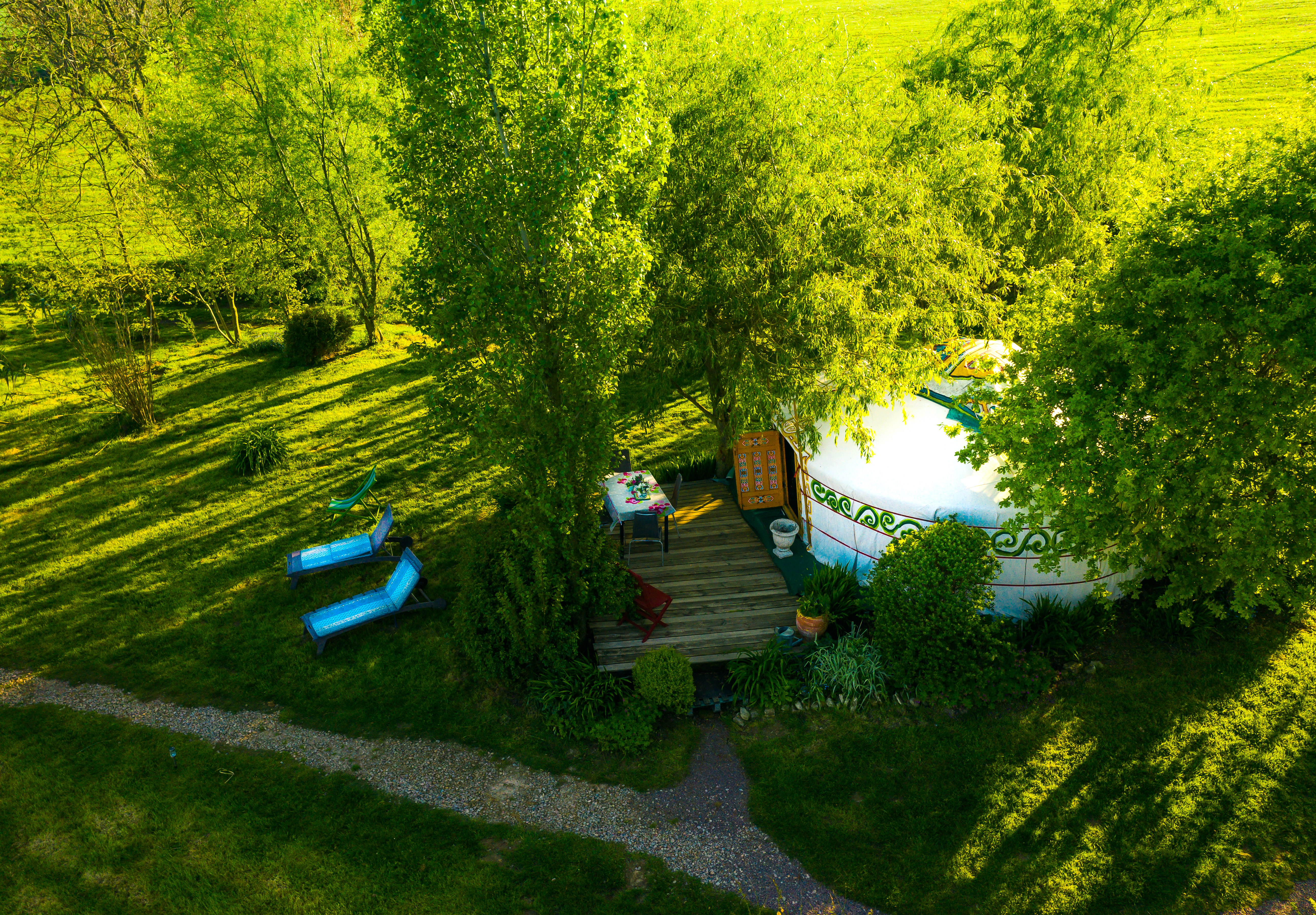 Vue aérienne de la yourte traditionnelle mongole orange de 28m² avec sa terrasse et son jardin.