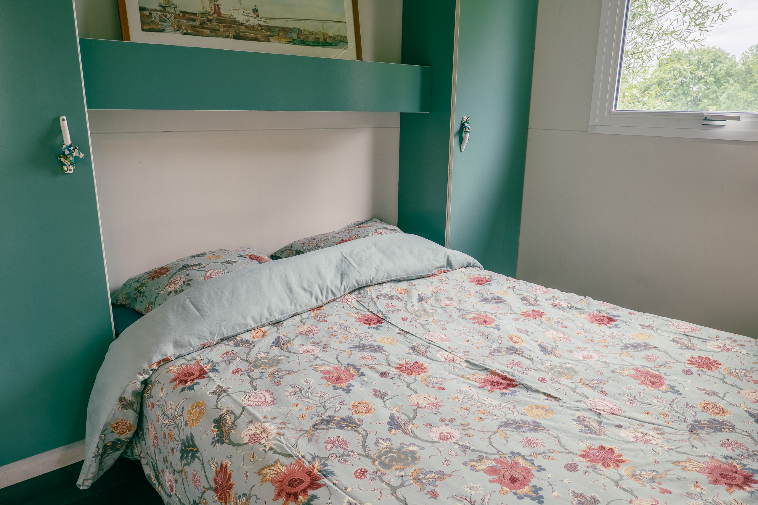 Au-Bonheur-Nomade - vue intérieure de la chambre parentale du chalet marron. Lit double avec rangement