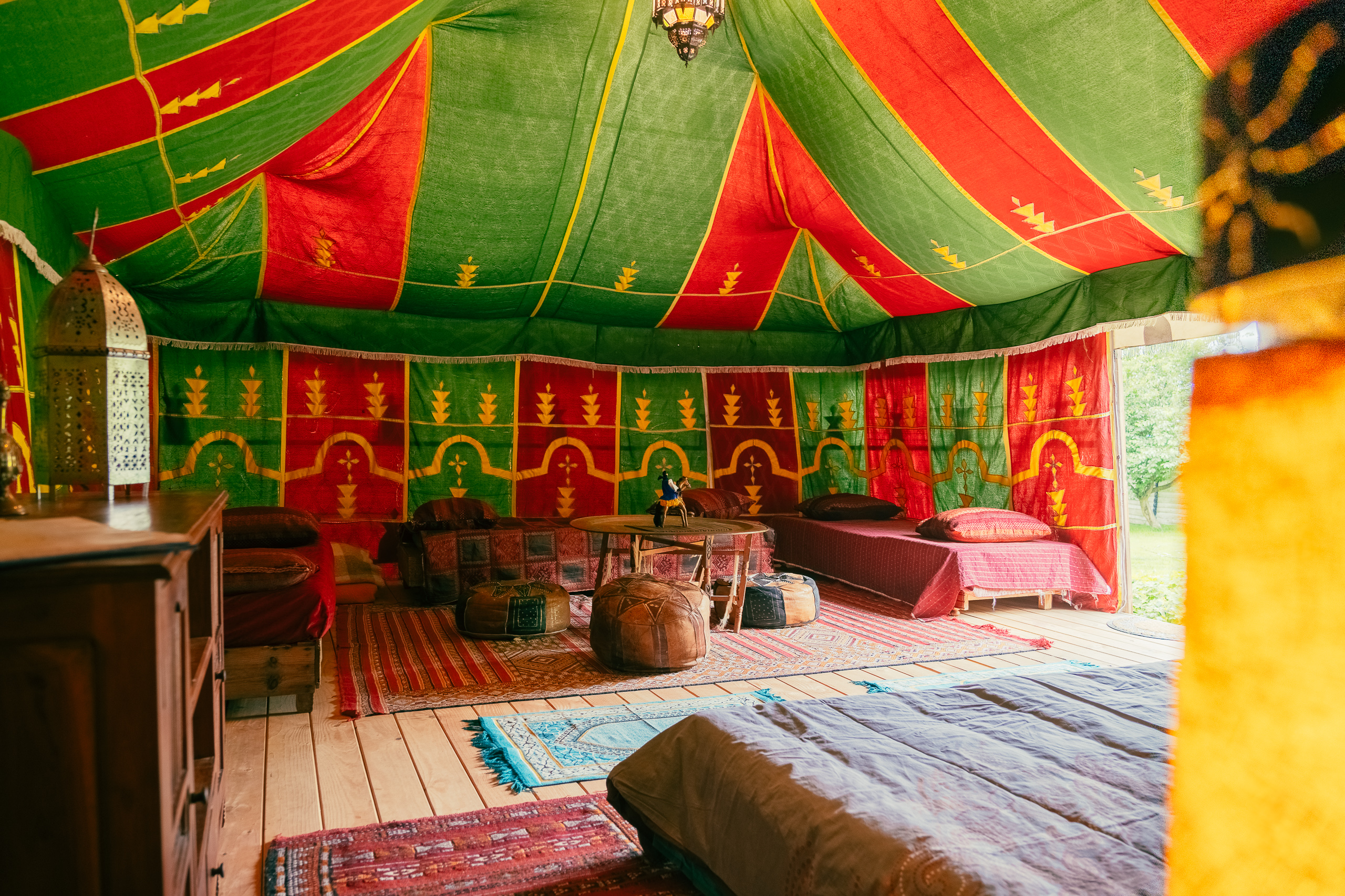 Au-Bonheur-Nomade - vue intérieure de la tente caïdale Marocaine. Plan sur le salon, table, banquette et pouf